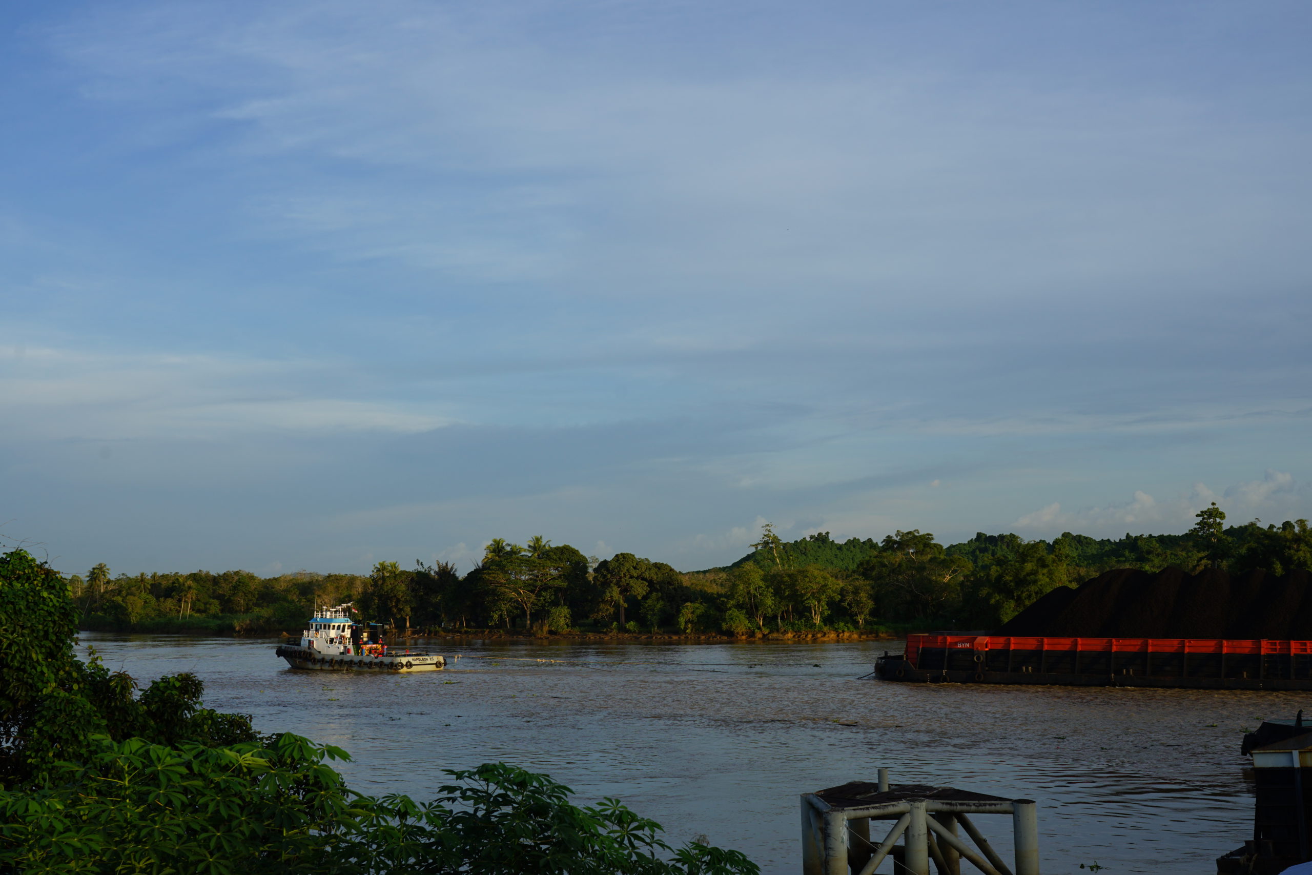 Kapal tunda menarik tongkang muatan tambang